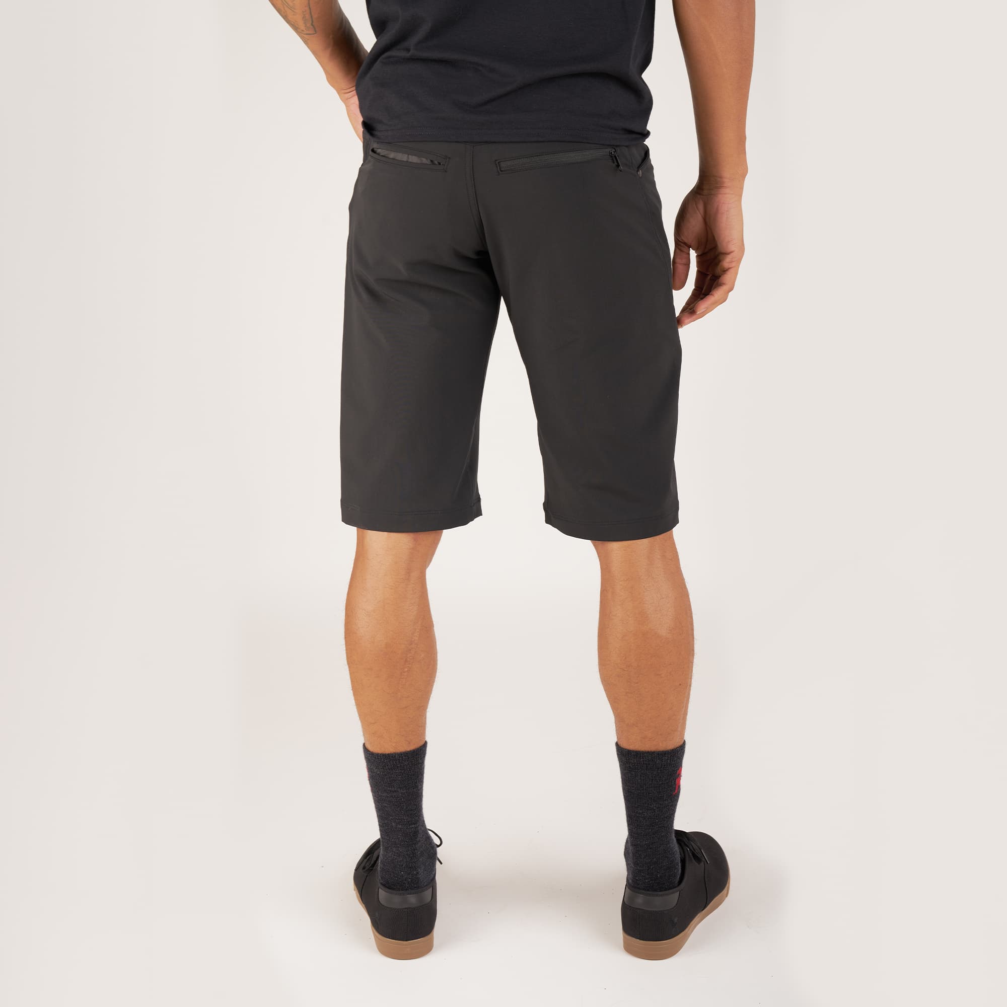 Men's Union Short 14" inseam in black worn by a man back view #color_black