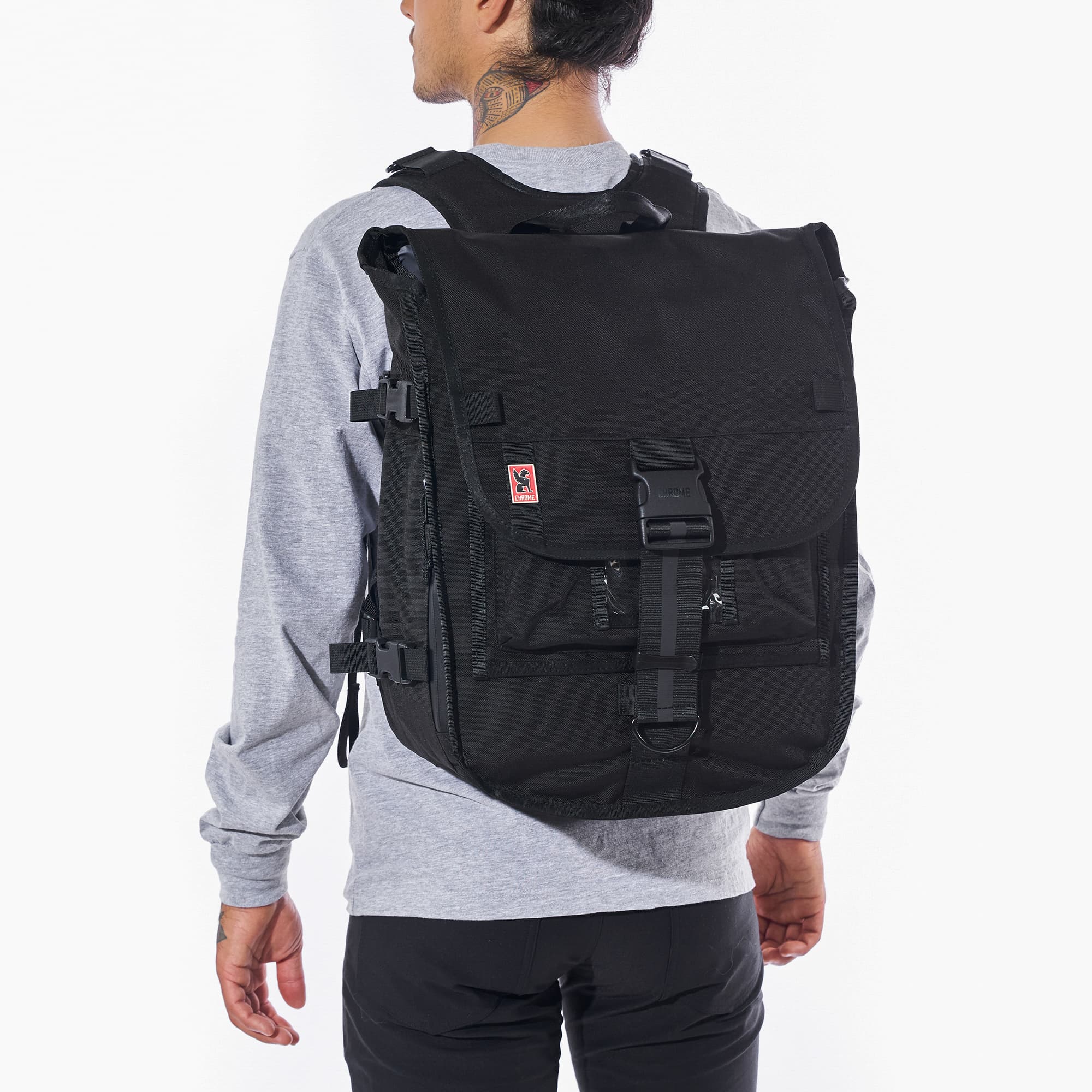 Warsaw medium size flap backpack in black worn by a man