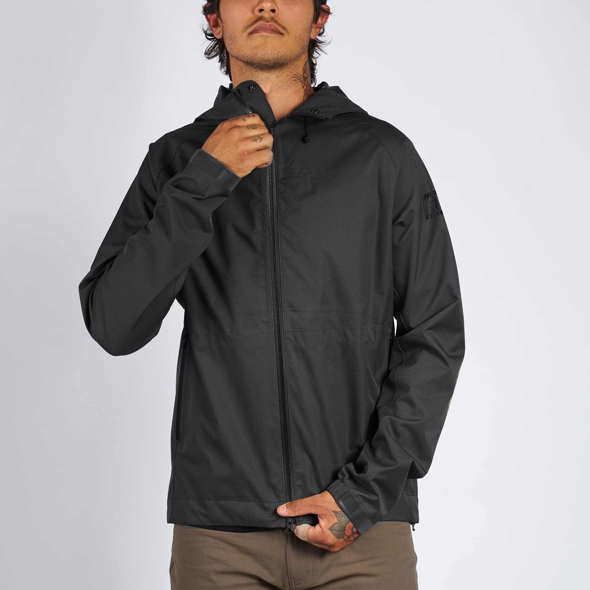 Waterproof rain jacket in black worn by a man front zip detail