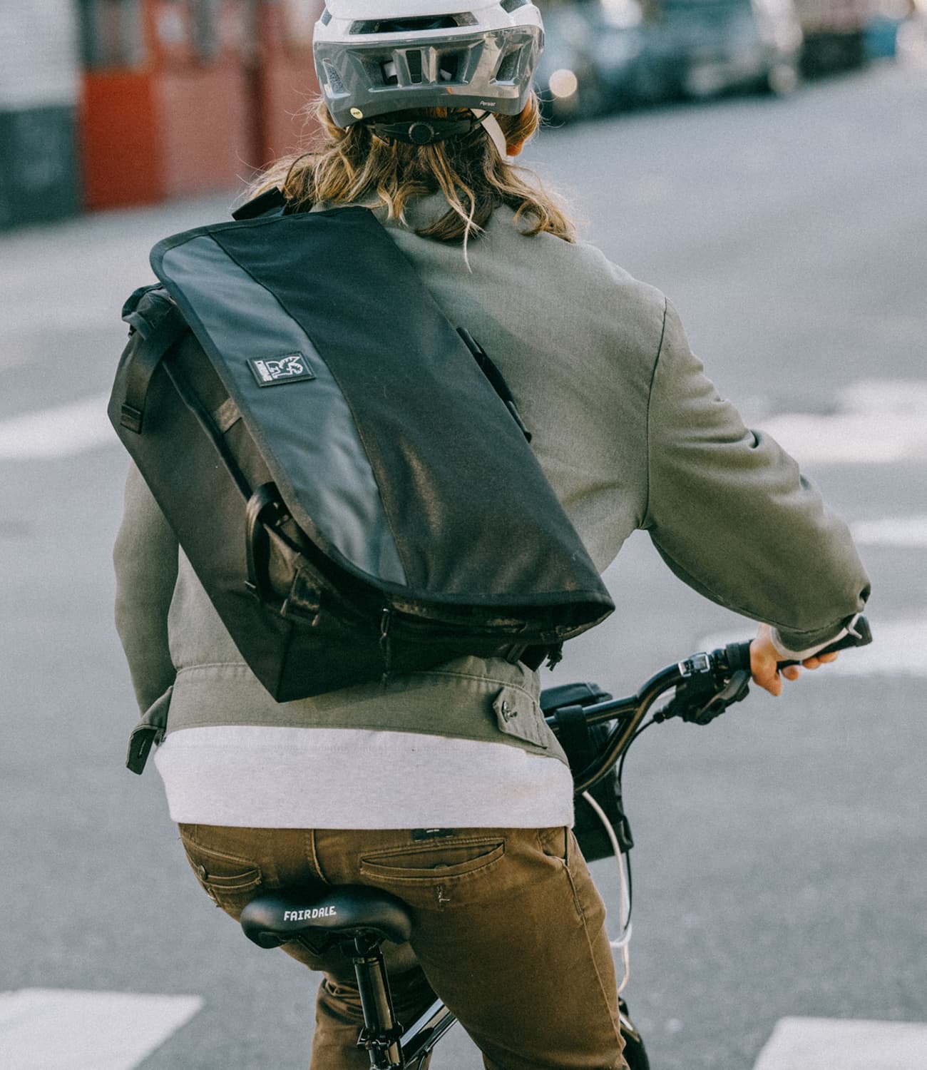 Buran III Messenger bag in black worn by a person riding a bike